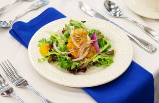 A plate of salad on a dressed table.