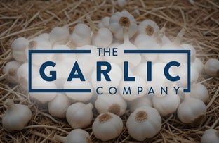 The Garlic company logo, layered on an image of garlic. 