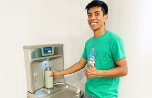 A man smiling with a reusable water bottle