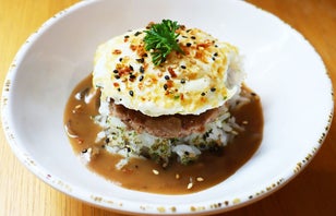 Loco Moco in a bowl on a wooden table.