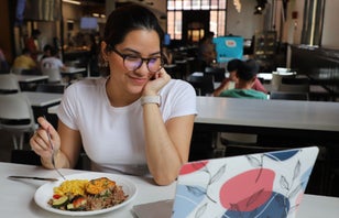 student eating in dining hall with computer