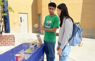 A green caption talking to a student.