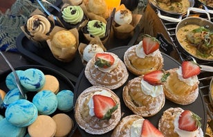 Assorted pastries and macarons on a catering table.