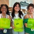Three people smiling and holding up bright neon-green, reusable plastic to-go containers in the Malkin Sacks Commons.

Three people smiling and holding up bright neon-green, reusable plastic to-go containers in the Malkin Sacks Commons.

