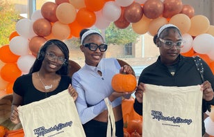 Three students at Fall Feast event in Broderick Dining Commons.